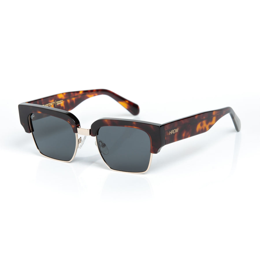 Sunglasses with tortoiseshell frame and dark lenses on a white background