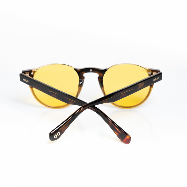 Round sunglasses with yellow lenses and tortoiseshell frame on a white background