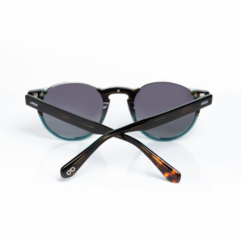 Sunglasses with tortoiseshell frame and dark lenses on a white background