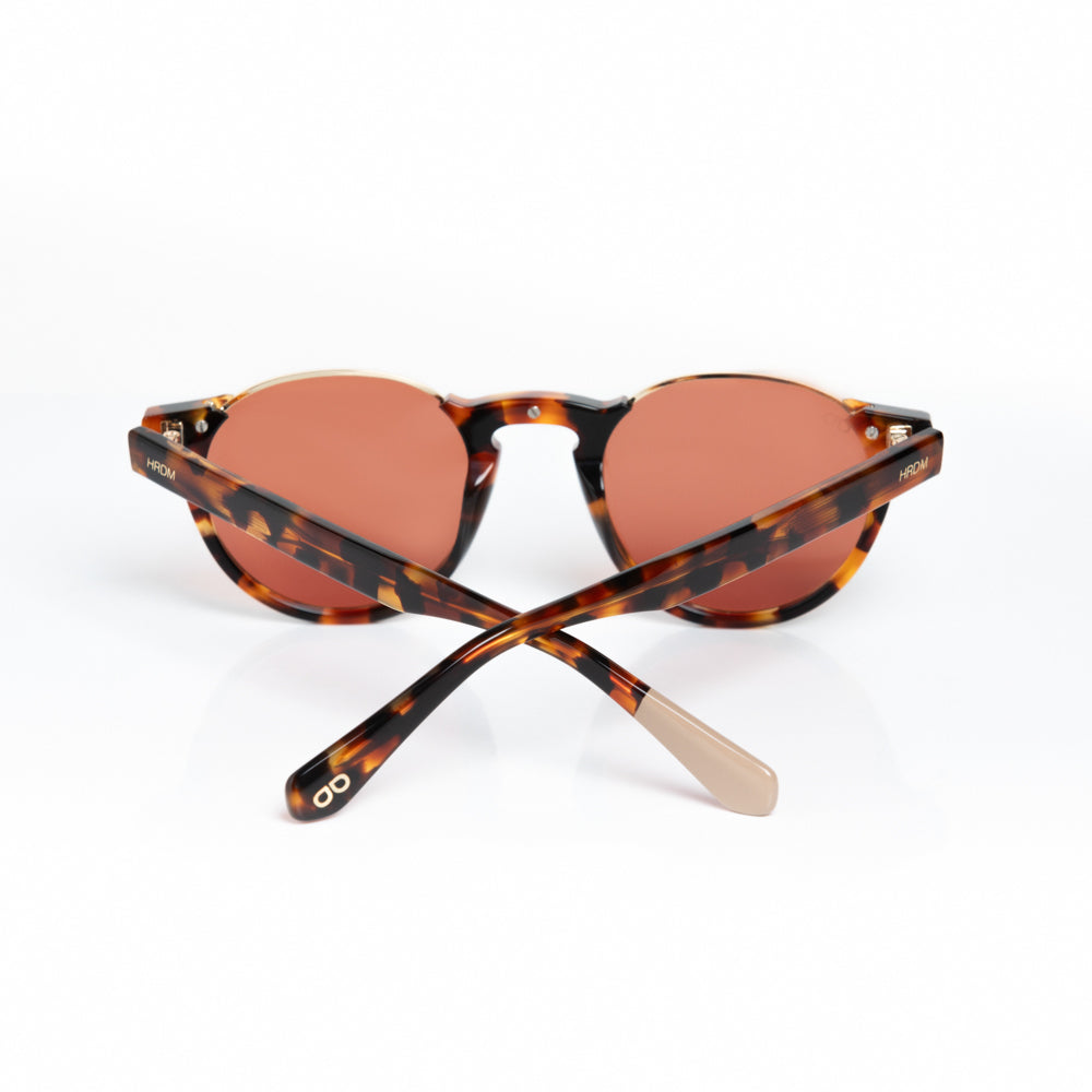 Sunglasses with tortoiseshell frame and brown lenses on a white background