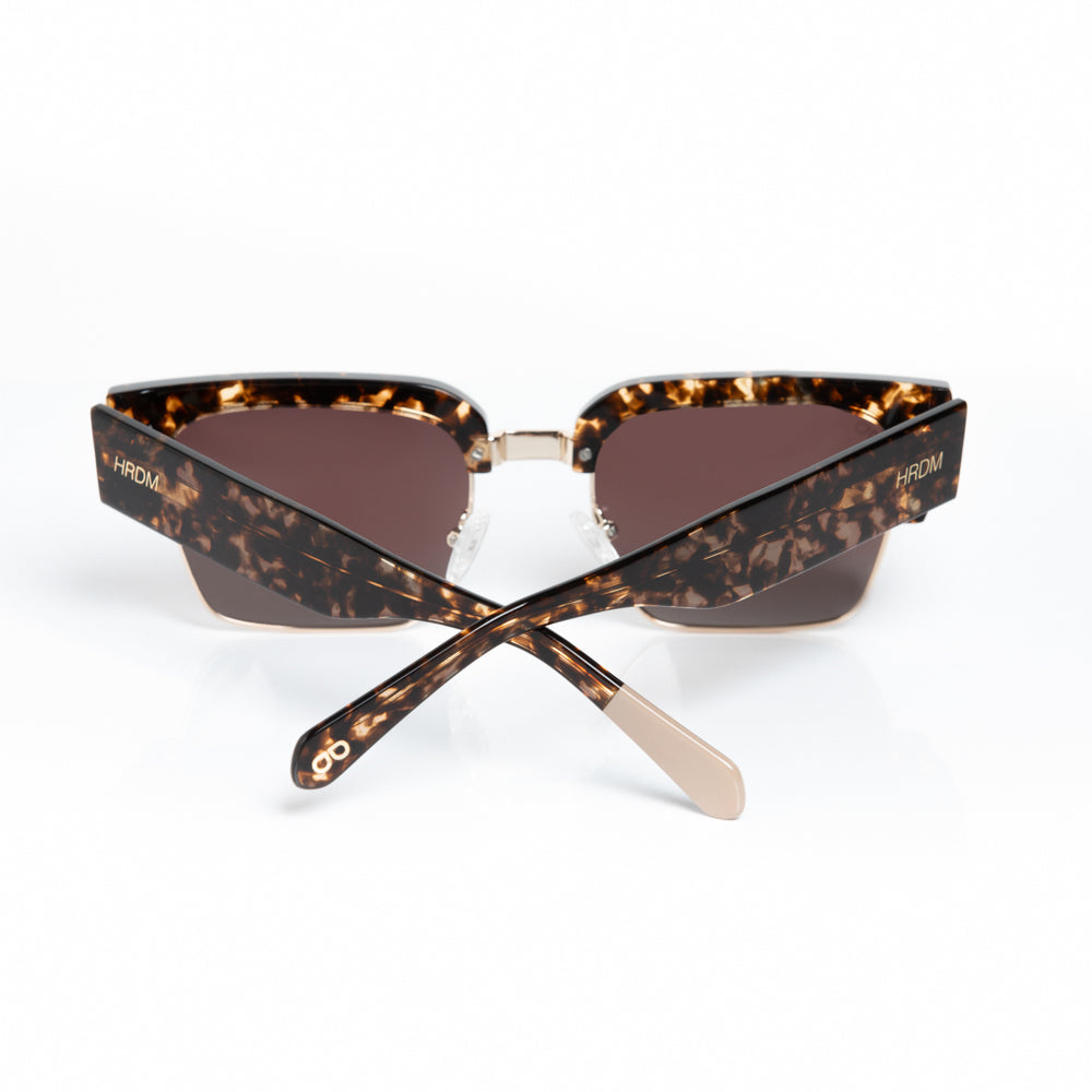 Tortoiseshell sunglasses with brown lenses on a white background
