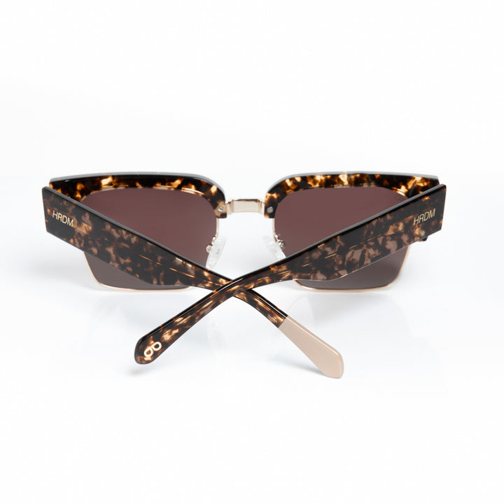 Tortoiseshell sunglasses with brown lenses on a white background