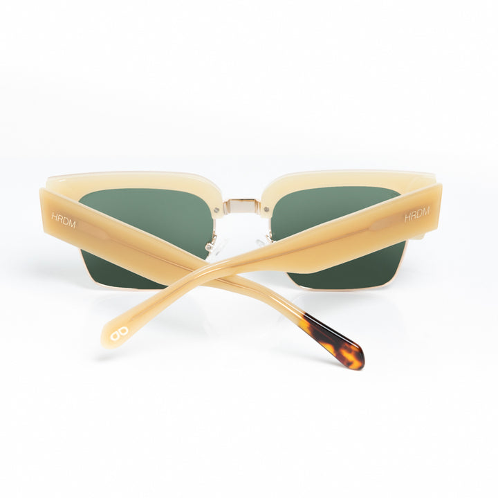 Sunglasses with beige frame and green lenses on a white background