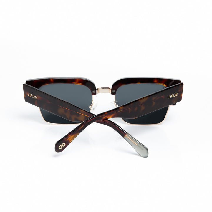 Sunglasses with tortoiseshell frame and dark lenses on a white background
