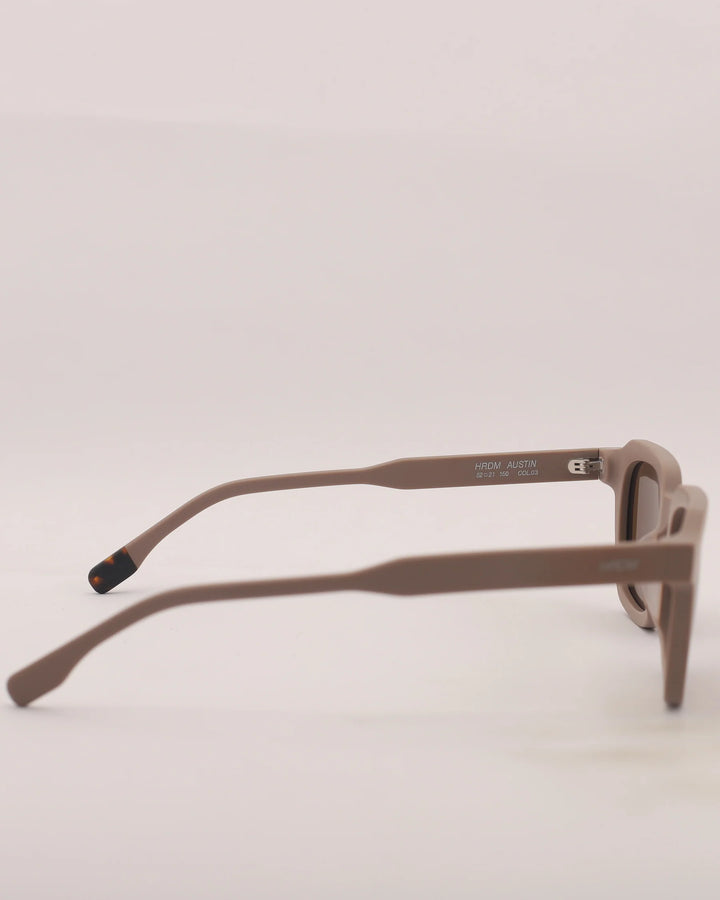 Brown sunglasses with thin frame on a light gray background