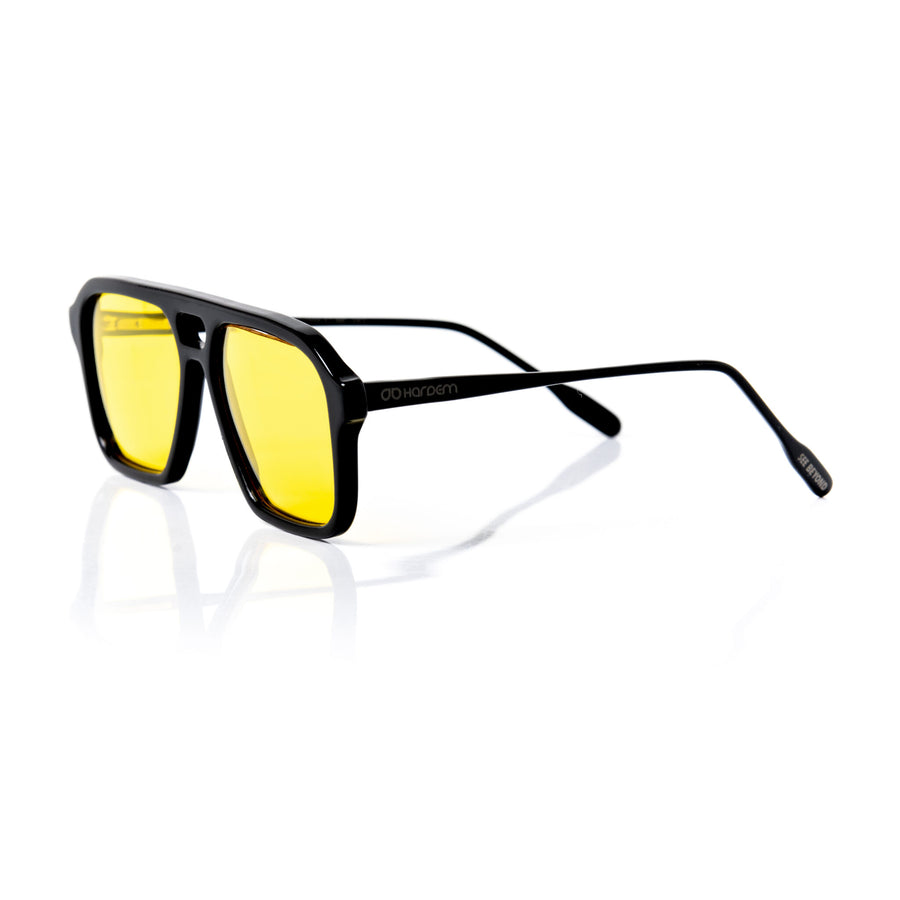 Sunglasses with yellow lenses and black frame on a white background