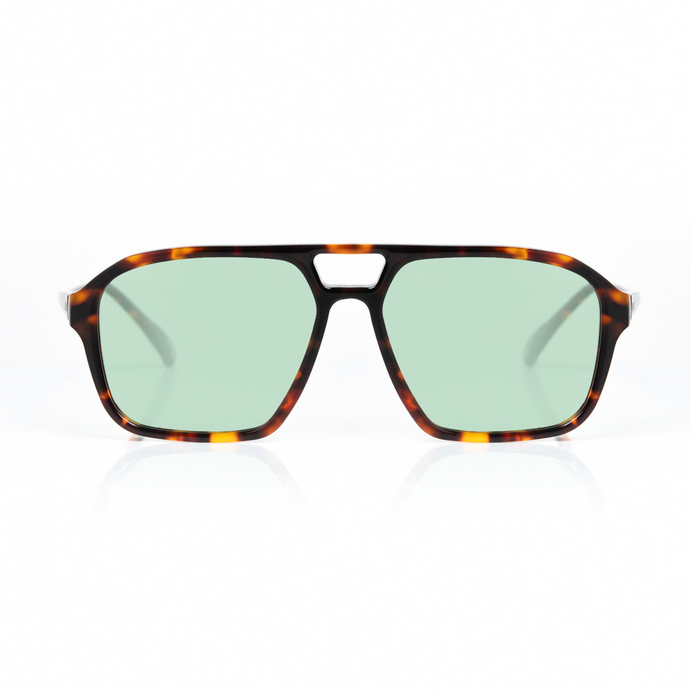 Sunglasses with tortoiseshell frame and green lenses on a white background