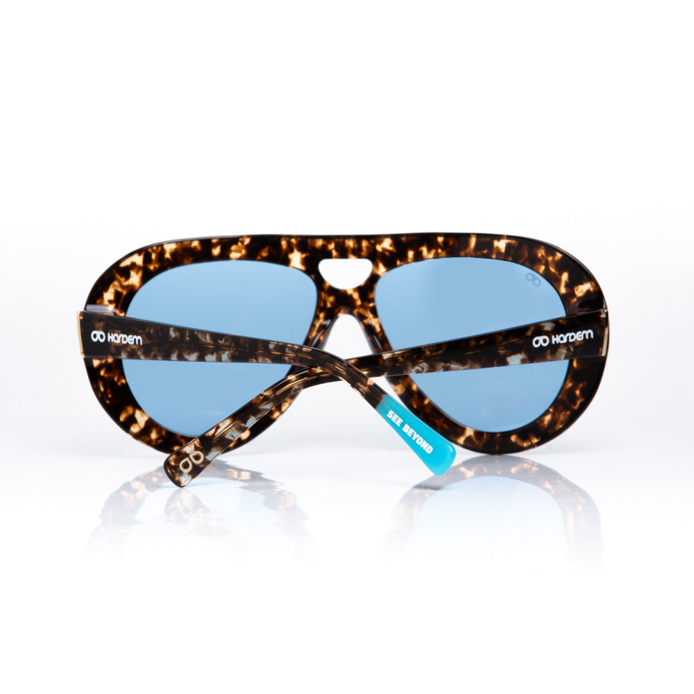 Sunglasses with tortoiseshell frame and blue lenses on a white background