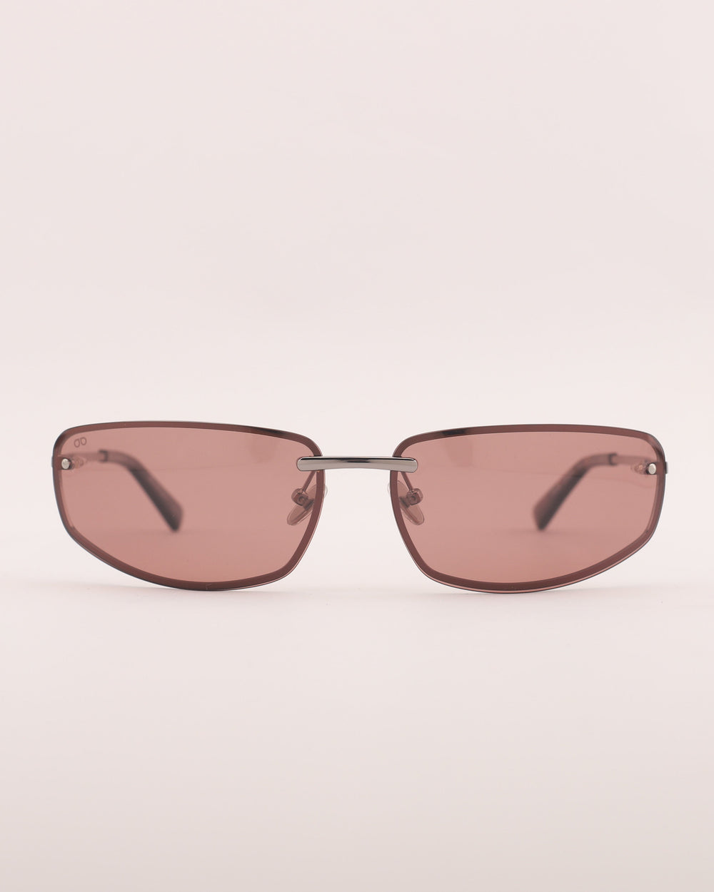 Sunglasses with pink-tinted lenses on a light beige background