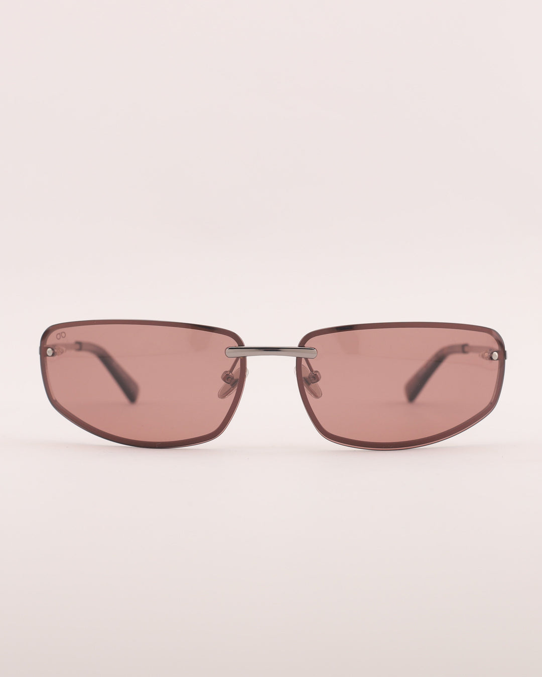 Sunglasses with pink-tinted lenses on a light beige background