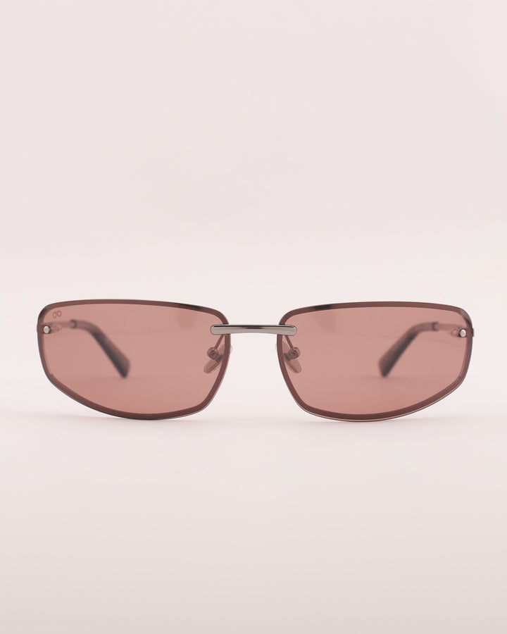 Sunglasses with pink-tinted lenses on a light beige background