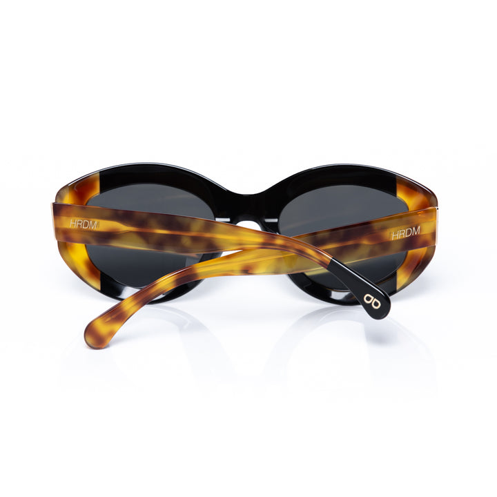Sunglasses with tortoiseshell frame and black lenses on a white background