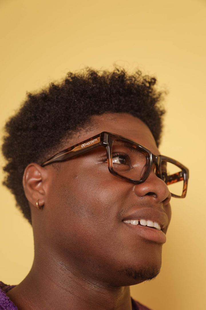 Person wearing glasses with a yellow background