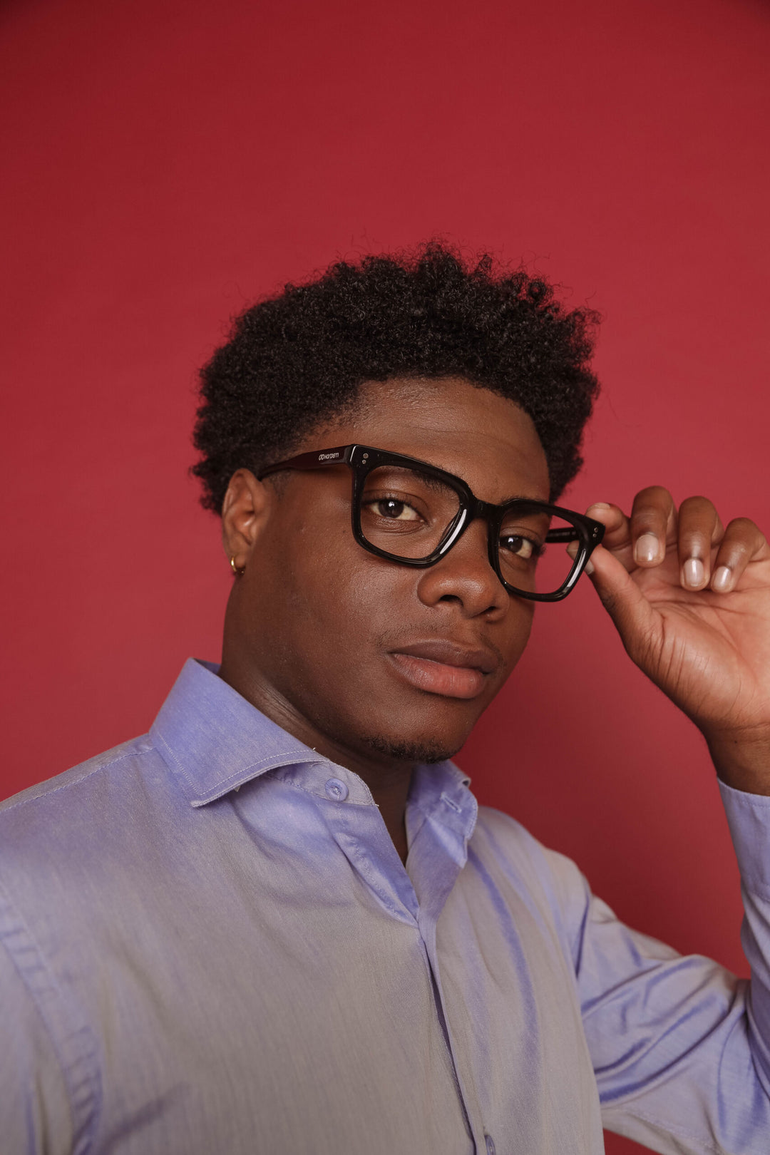 Man wearing glasses with a red background