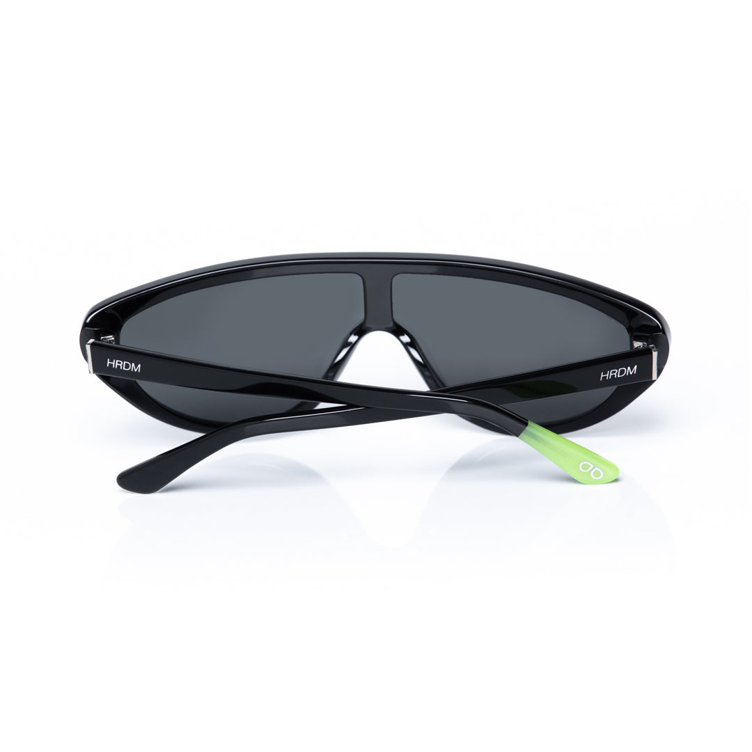 Black sunglasses with a green accent on a white background