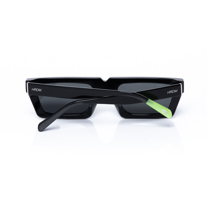 Black sunglasses with a green accent on a white background