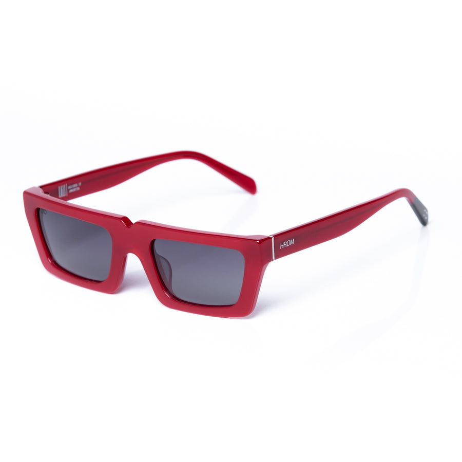 Red sunglasses with dark lenses on a white background