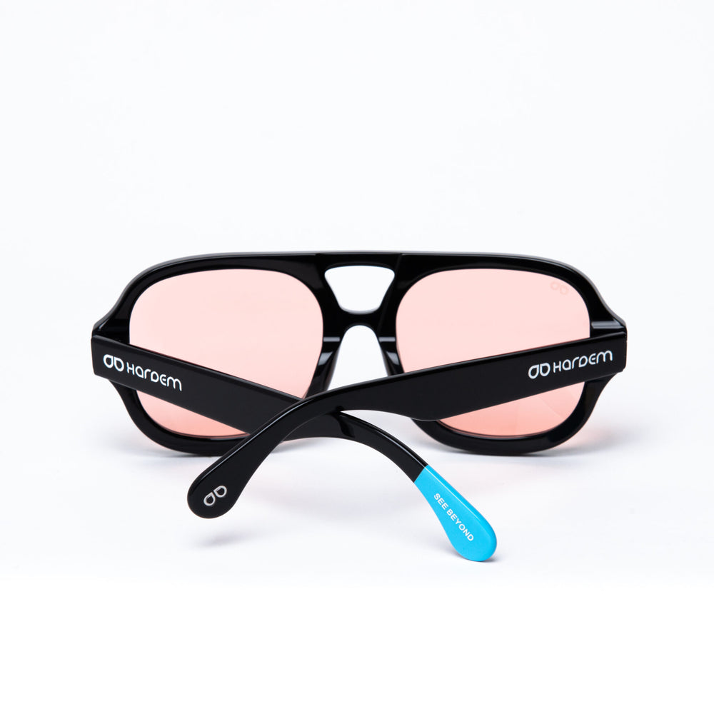 Black sunglasses with pink lenses on a white background