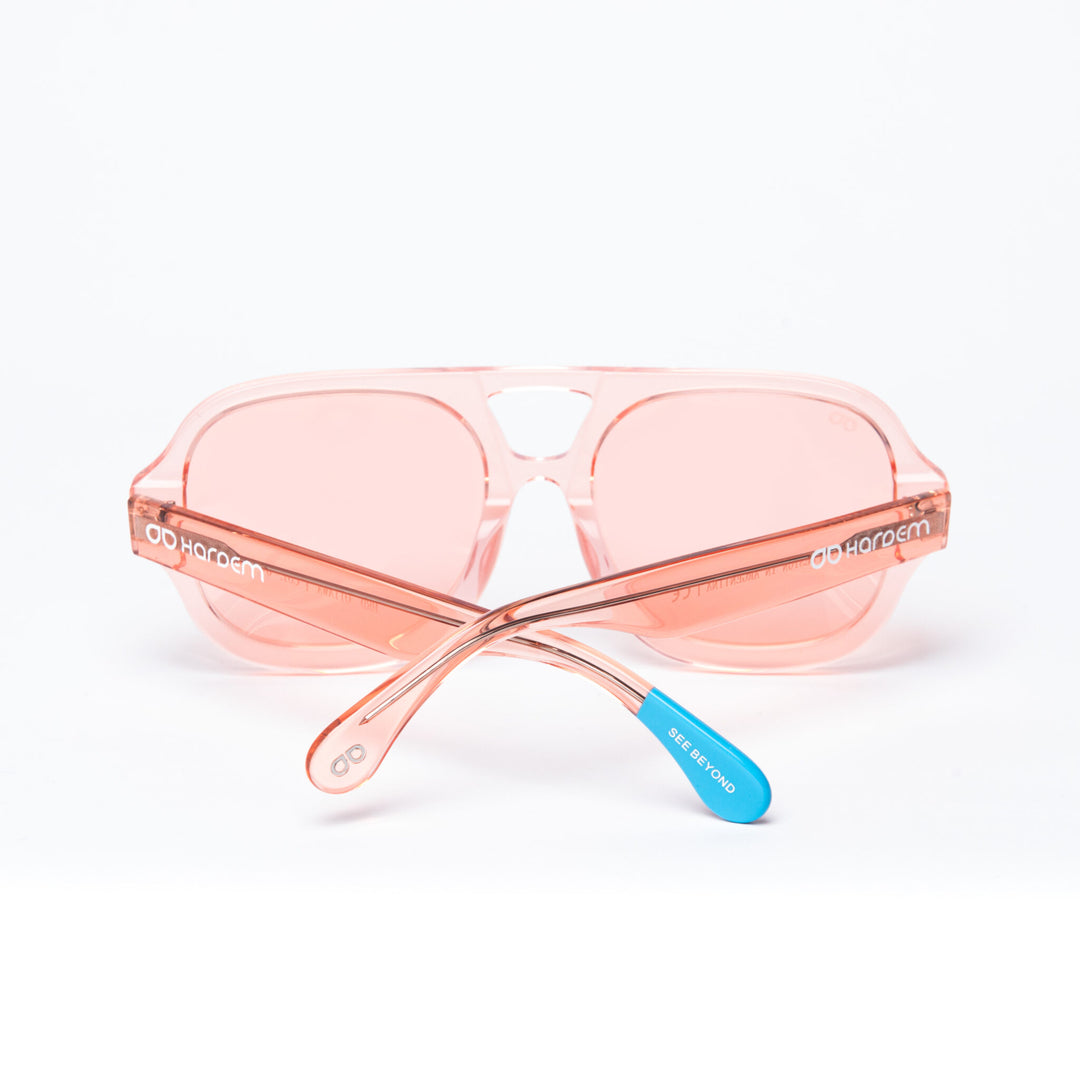 Pink sunglasses with a blue arm on a white background