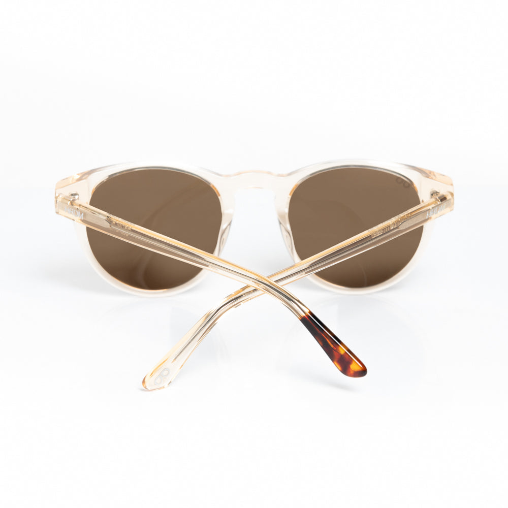 Pair of sunglasses with gold frame and tortoiseshell accents on a white background