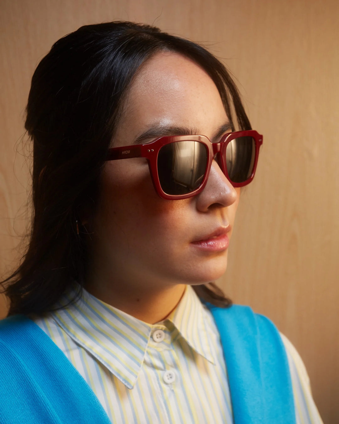 Person wearing red sunglasses with a neutral background